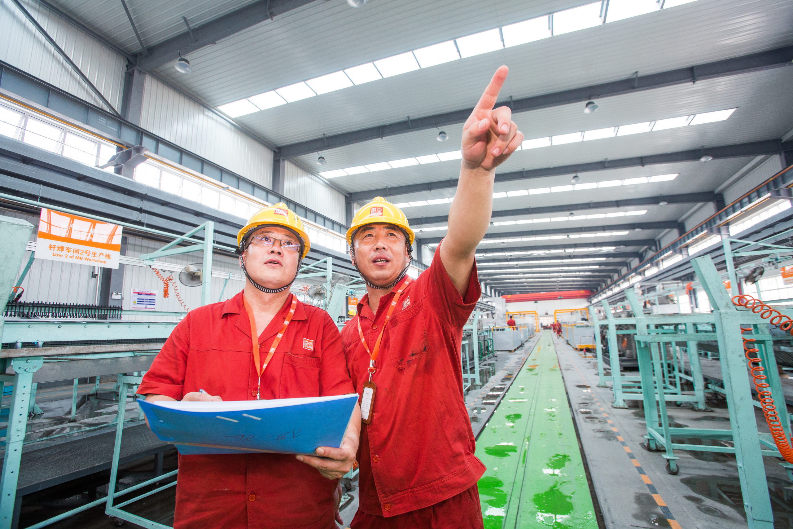 Third production line in manufacturing plant China, two employees working